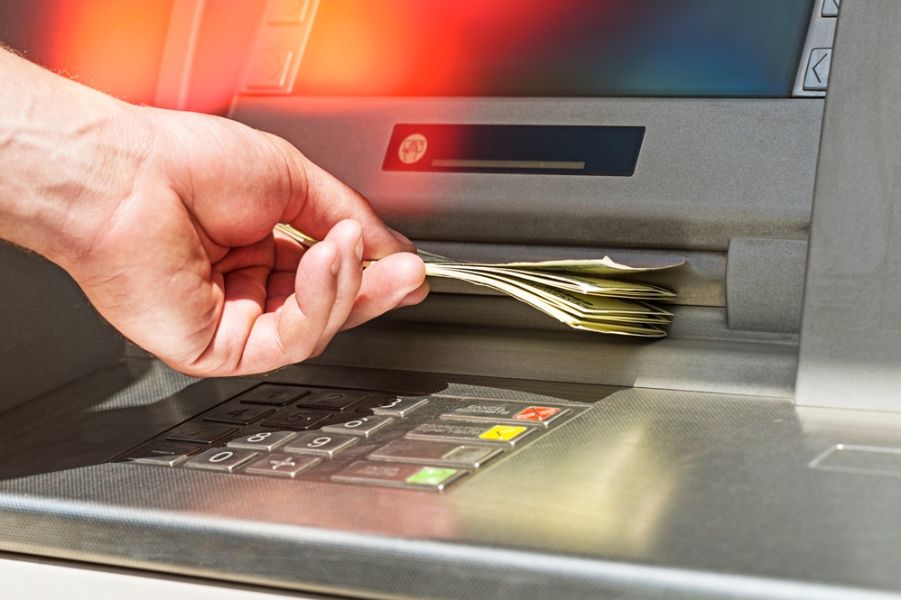 Hand with taking money from an ATM. Atm bank banking paper currency bank teller removing currency