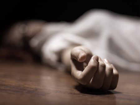 The dead woman’s body. Focus on hand